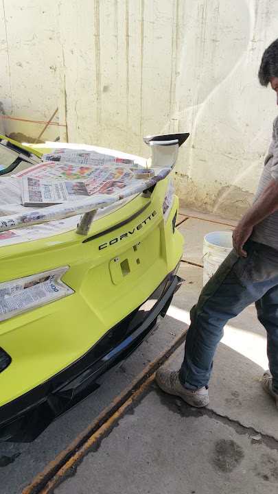 Parte trasera del Corvette amarillo enmascarada durante el trabajo de pintura en Hawley